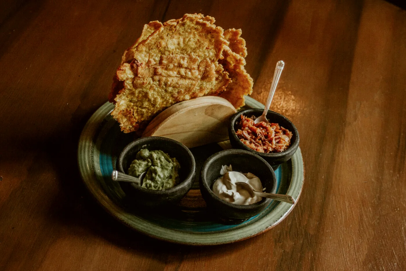 Trío de patacones con guacamole, sour cream y hogao